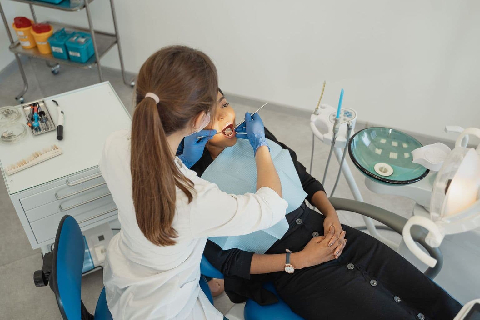 Dentista atendendo uma paciente na cadeira do consultório